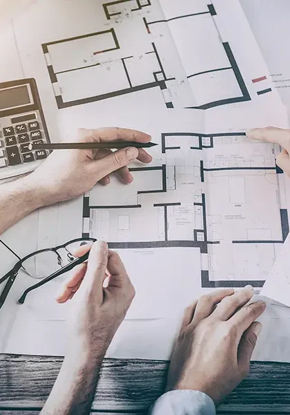 Floorplan diagram on table with hands reaching in to point out features
